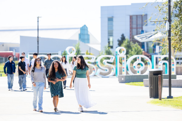 Students walking in front of Mission sign