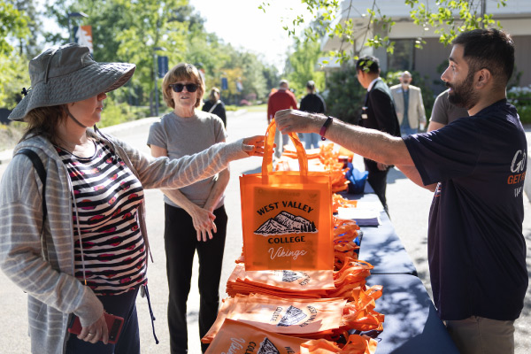 Ambassador handing out West Valley tote