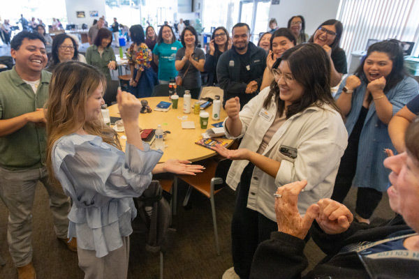 Two Mission employees playing Rock Paper Scissors during Classified Conference